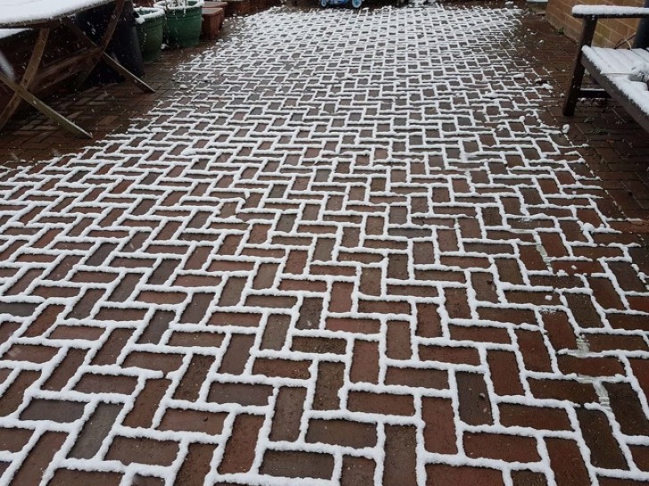 Curious ways in which snow settles --- here only on the outlines of the patio floor bricks ...