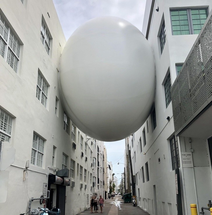 A spherical construction connects two buildings.