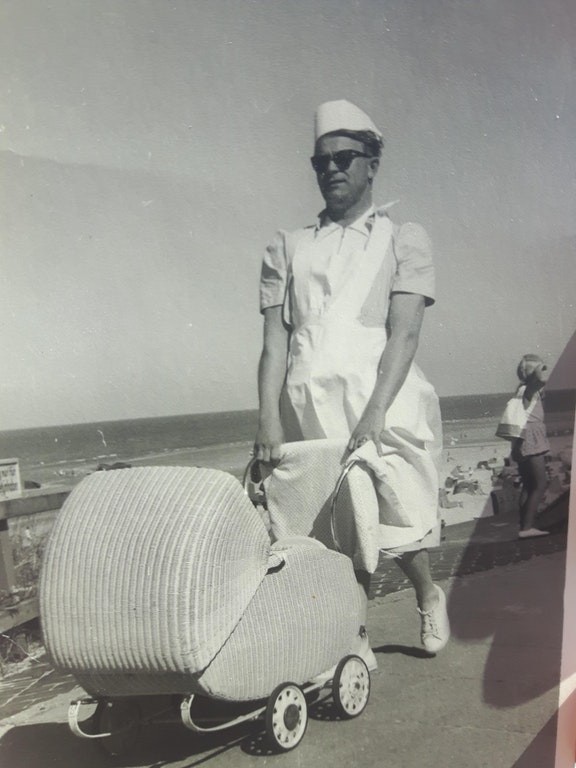 Un homme vêtu avec des vêtements féminins pour plaisanter qui emmène son nouveau-né, dans les années 1950, pour une promenade