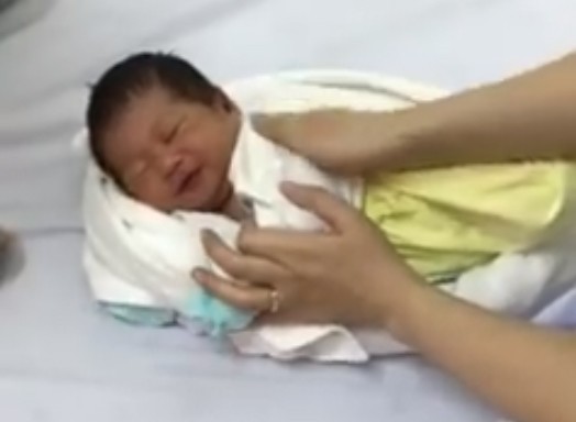 En sjuksköterska visar sin metod för att få en bebis att somna med hjälp av en handduk och ett badlakan - 4