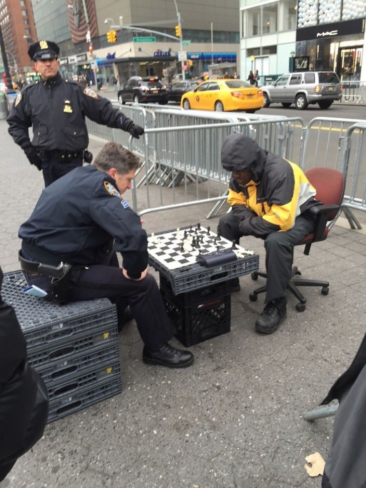 Ein Polizist hält für eine Partie Schach mit einem Obdachlosen an: das bedeutet auch Zivildienst!