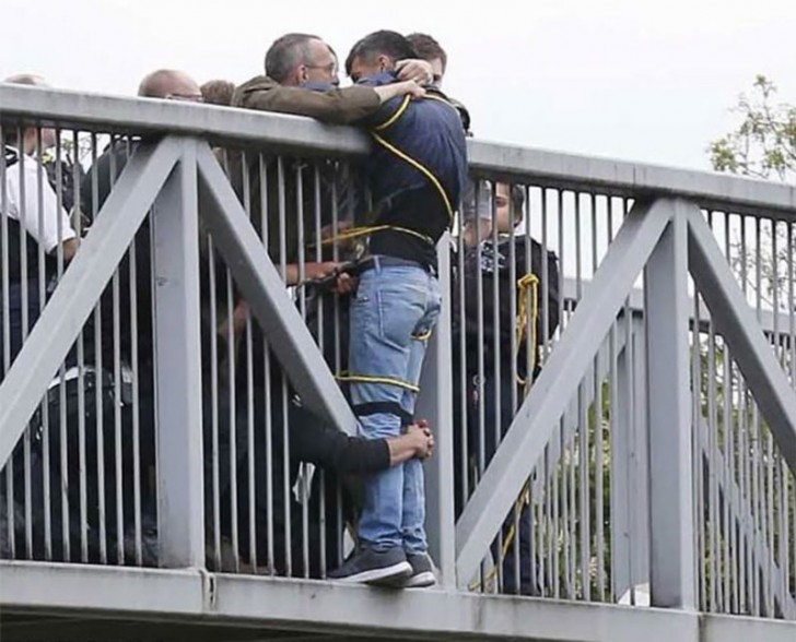 De jongen wilde zich van de brug gooien, maar voorbijgangers klampten zich aan hem vast.