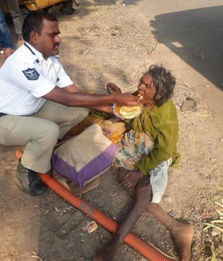 Na Índia, um policial ajudou uma moradora de rua a comer. Ela estava tão fraca que não conseguia nem comer sozinha.