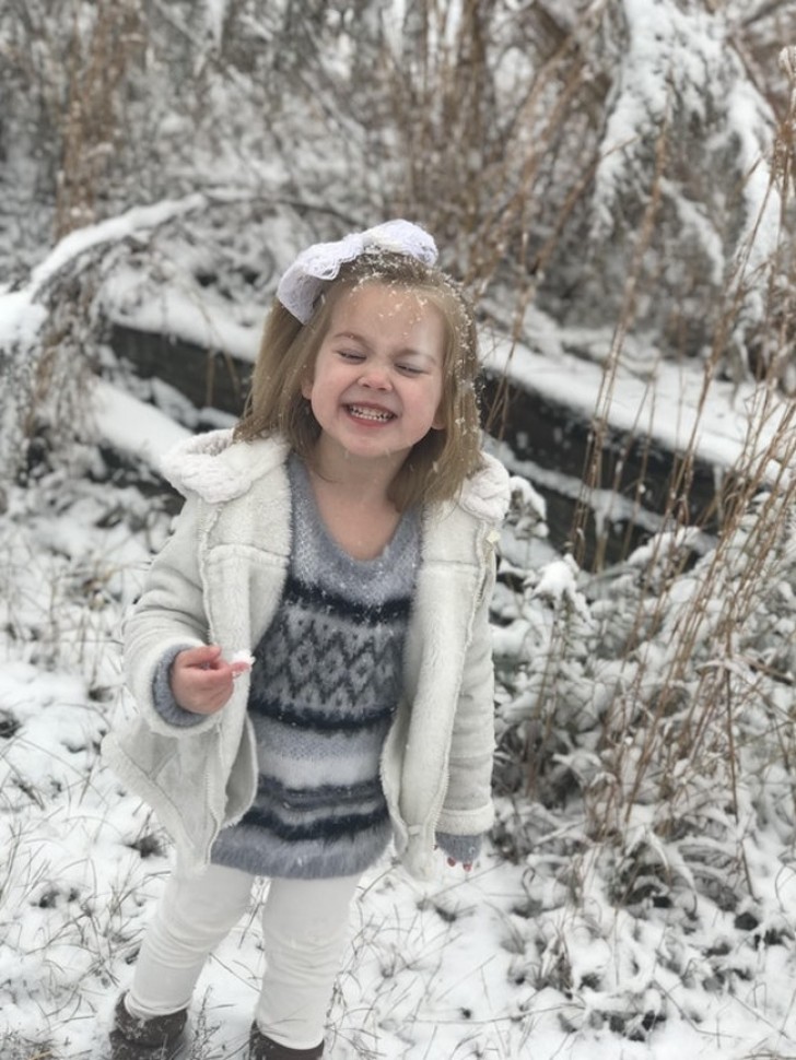 13. È la prima volta che questa bambina vede la neve e sembra essere al settimo cielo