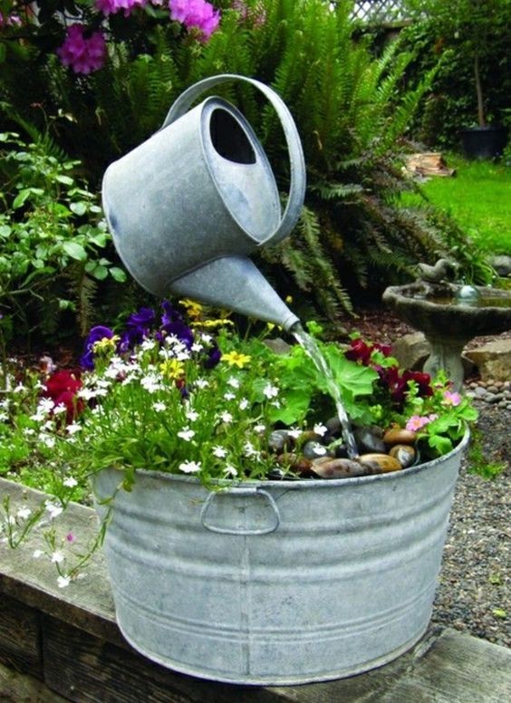 13. A transparent plexiglass tube connects an old galvanized tub that is now a plant container and the watering can, with a truly admirable final effect!