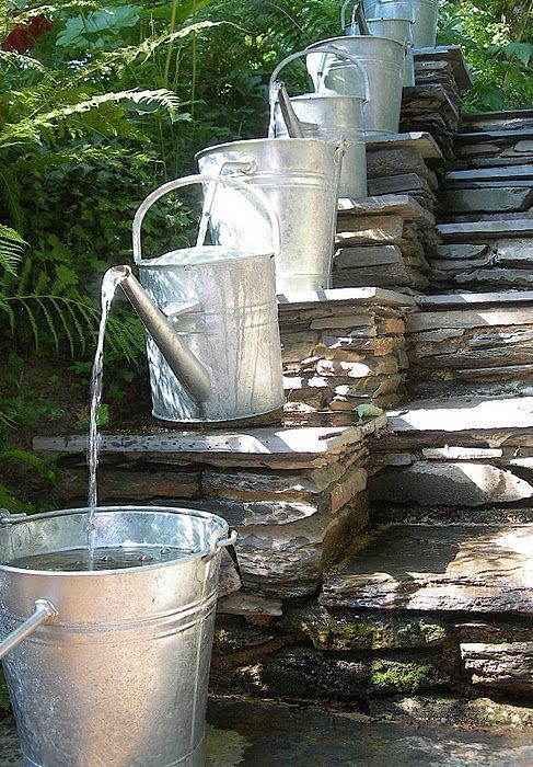 14. If watering cans fascinate you --- then, you might consider using a whole series of them lined up in a row ...