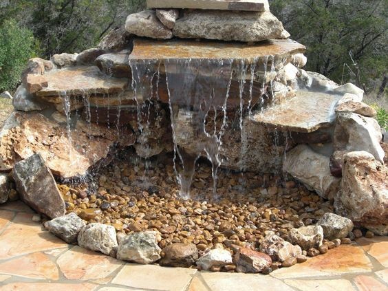 9. Making a small waterfall is not difficult! Just install an underground catch basin and pump system that continuously pulls the cascading water back up to flow over the rocks. Decorate the 