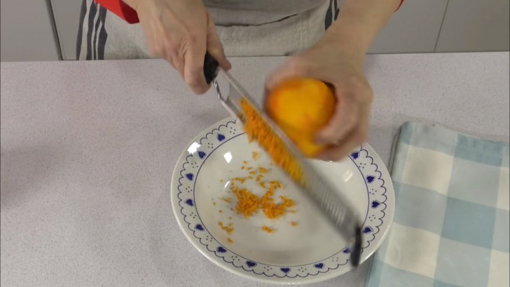 Commencez par gratter l'écorce d'orange : une partie sera utilisée pour le dessert, l'autre pour le sirop.