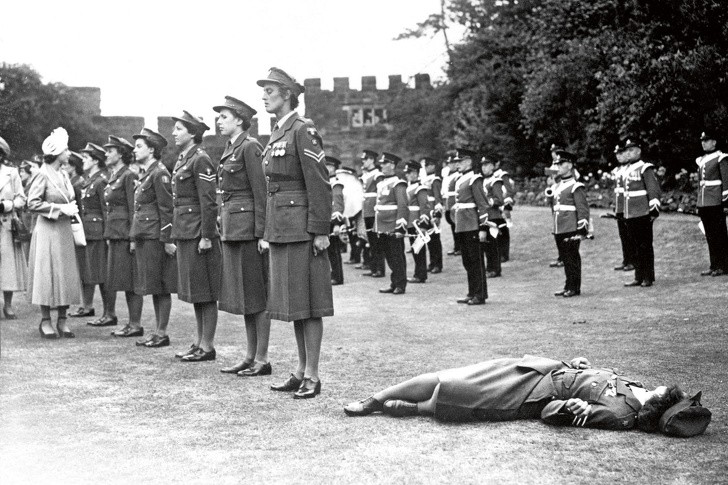 19. Eine Soldatin wird bei einer Inspektion durch Queen Elizabeth, 1949, durch die Hitze ohnmächtig.