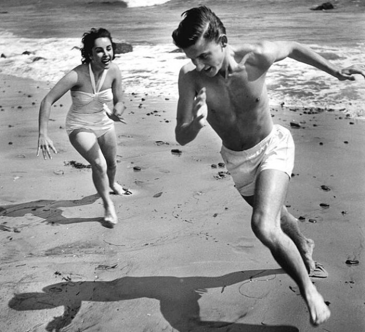 12. Elizabeth Taylor und Roddy McDowall jagen sich gegenseitig an einem kalifornischen Strand, 1948