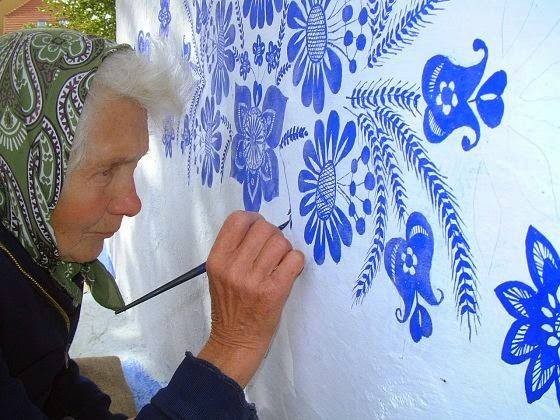 Anežka paints the walls of the houses of her village with floral and traditional motifs. Despite arriving arrived at the age of 87, her hand is still firm and able to draw minute details.