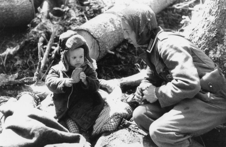 1. Ein deutscher Soldat bietet 1942 einem russischen Kind Brot an.