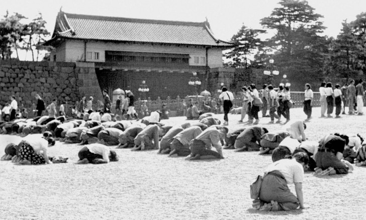 14. Japanische Bürger werfen sich vor dem Kaiserpalast in Tokio nieder, während Kaiser Hirohito die Niederlage Japans im Zweiten Weltkrieg (15. August 1945) ankündigt