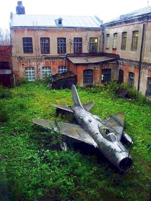7. Un avion militaire abandonné dans la cour de ce bâtiment également abandonné