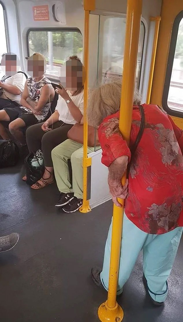 Une dame âgée reste debout dans le train pendant que des jeunes écoutent de la musique, absorbés par leurs téléphones - 1