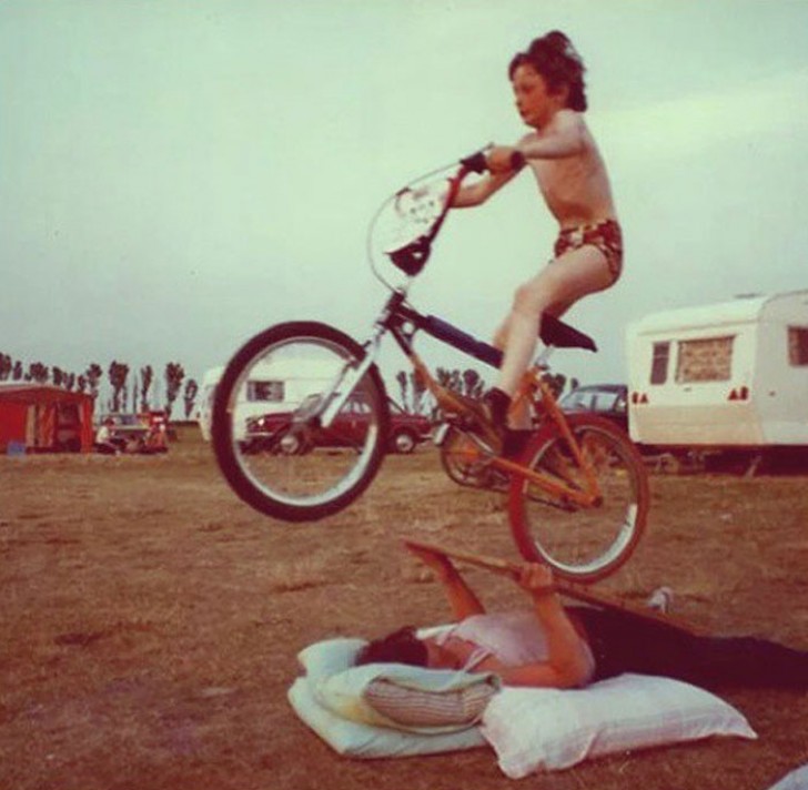 "1980. Meine Mutter hält eine improvisierte Rampe,damit ich mit meinem Fahrrad springen kann."