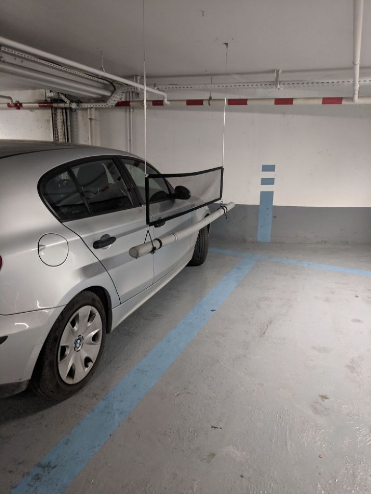 Dans ce parking il ya des tiges souples qui suggèrent la meilleure position de la voiture, pour éviter de toucher la carrosserie du voisin avec la portière.