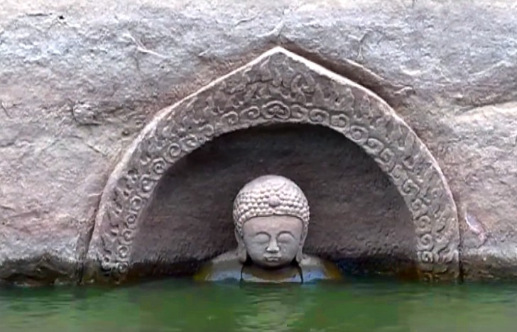 Een prachtig 600 jaar oud standbeeld van Boeddha komt tevoorschijn uit de wateren van een meer - 1