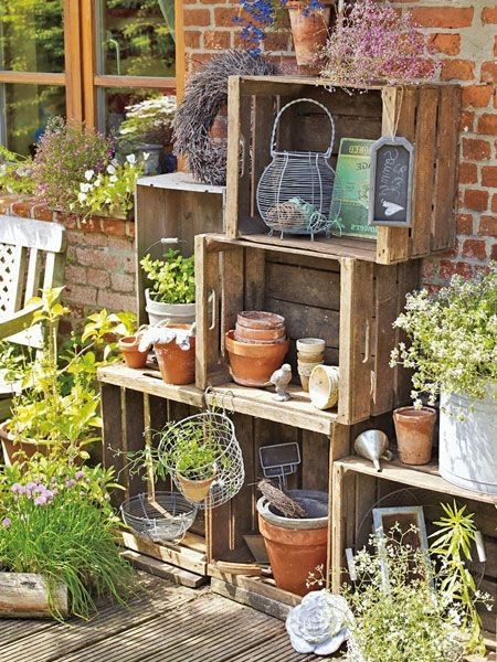 2. Una semplice composizione di cassette di legno per ricavare un mobile da giardino con mensole e ripiani per piante, vasi da fiori e oggetti ornamentali.