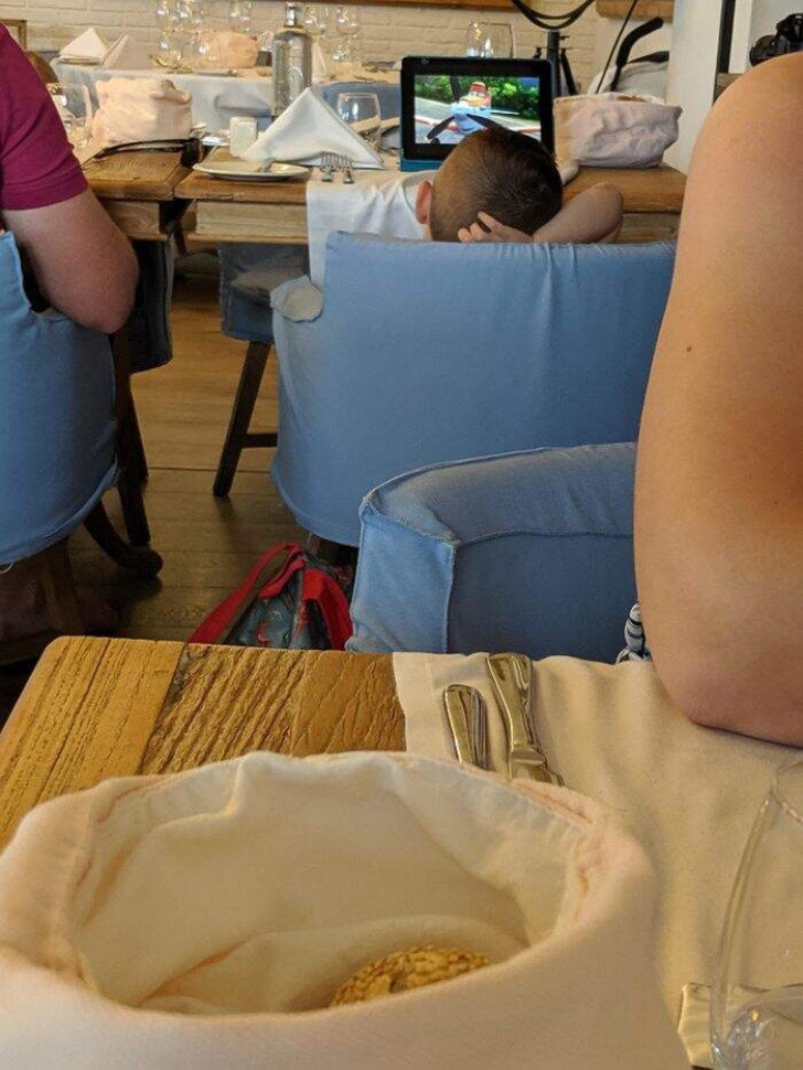 2. Estos padres permiten al hijo de mirar una película a todo volumen en la tablet, mientras están en el restaurant