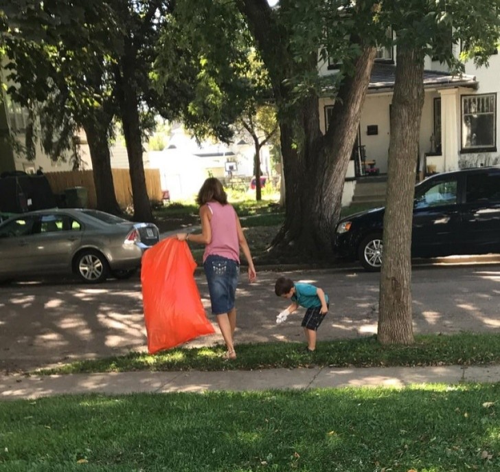 11. Questa mamma sta portando suo figlio a raccogliere rifiuti per il quartiere, spiegando che la Terra è l'unico pianeta che abbiamo