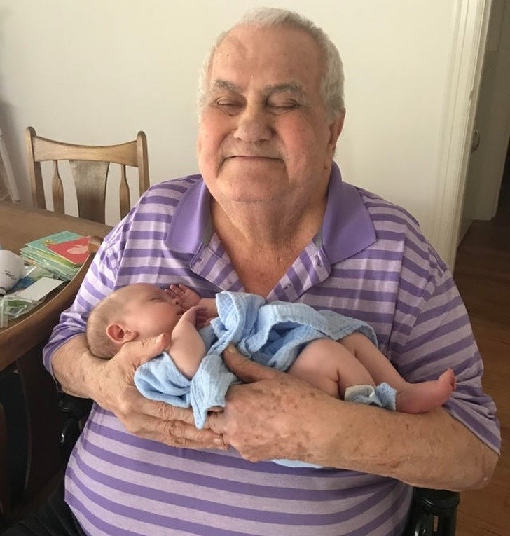 A proud and emotional grandfather who holds his tiny grandson in his arms!
