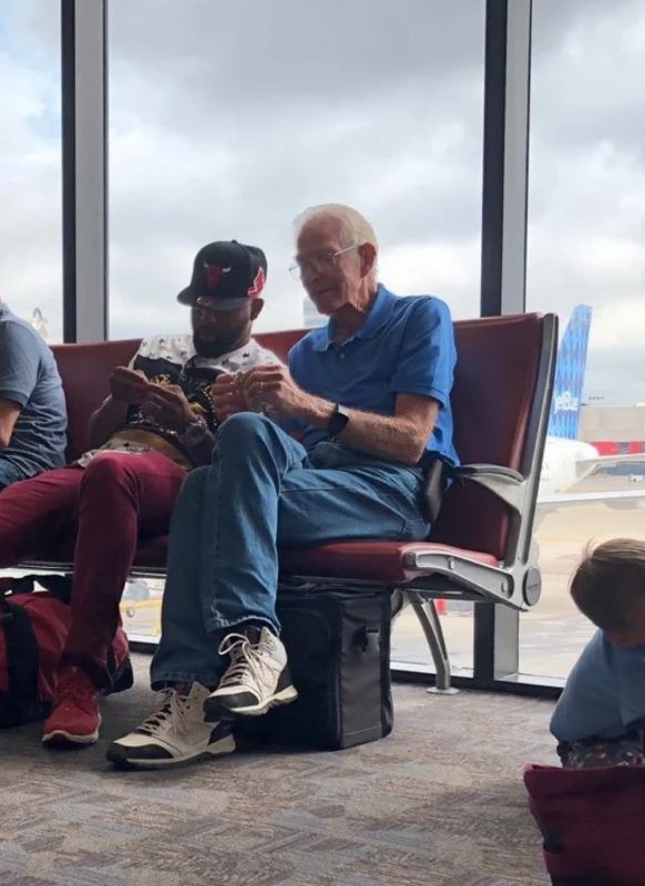7. An elderly gentleman teaches a young man how to make origami structures while waiting for a delayed flight.
