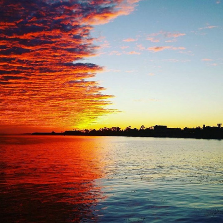 De perfecte symmetrie van de wolkenbank die samenkomt met het rood van de zonsondergang...