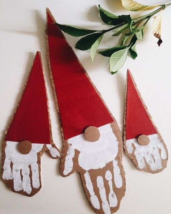 4. Cartone, cartoncino rosso e l'impronta della manina bianca: non serve altro per dei Babbo Natale stilizzati come questi
