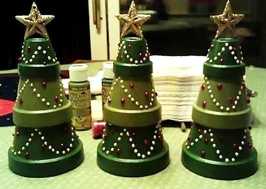 1. Vasi di misure sempre più piccole, dipinti di diverse sfumature di verde e poi decorati con festoni: ecco dei simpatici alberelli di Natale