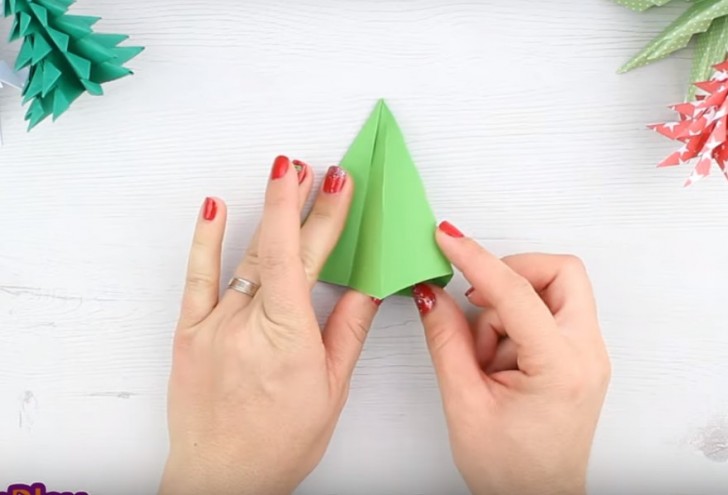 8. Posizionate il triangolo in modo che il vertice punti in alto, sollevate il lembo esterno e col dito spingete sulla piega che viene in fuori in modo da portarla all'interno del triangolo