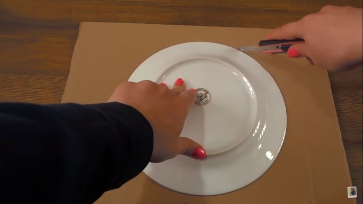 1. Ritagliate una sagoma rotonda sul cartone, aiutandovi con il piatto di diametro maggiore e un taglierino