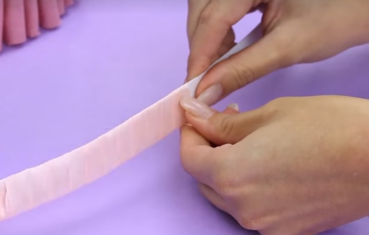 Rivestite una delle strisce di plastica con un nastrino e fissatelo per bene