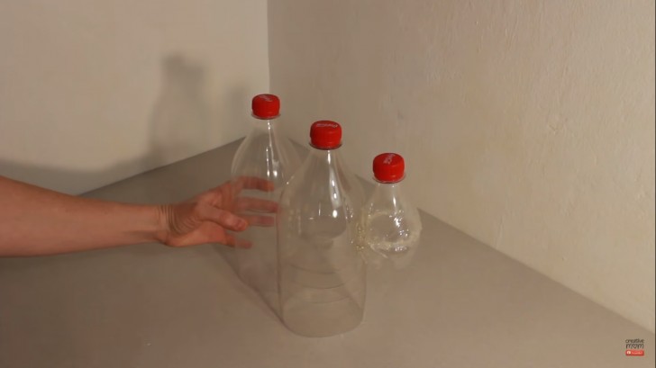 4. Mettete al centro la bottiglia più grande e incollate le altre due ai suoi lati, tenendo la piccola in alto come in foto