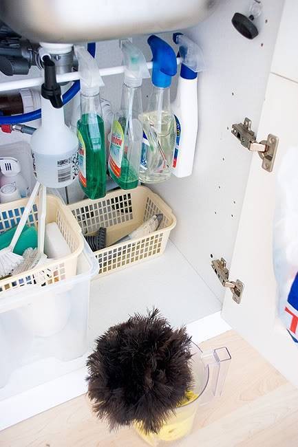 7. Installate un'asta del genere sotto al lavandino per avere bottiglie spray e guanti a portata di mano, ricavando ulteriore spazio nel mobile