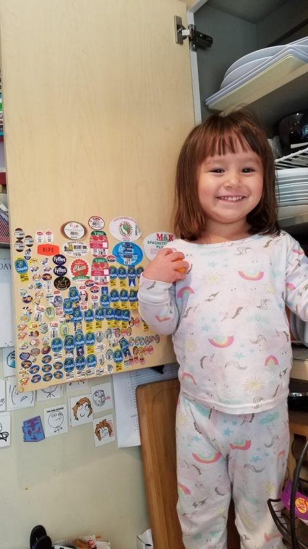 9. Whenever she eats fruit or vegetables, Dad lets her stick the product sticker on the door. Look how proud she is!