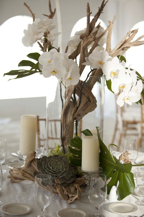 4. Un vaso di vetro con rami secchi e orchidee bianche