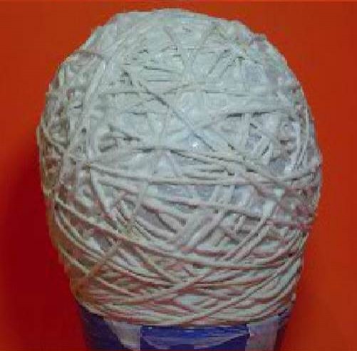 2. Avvolgete la lana (o altro filato) attorno al palloncino, impregnando il filo con la colla usando il pennello