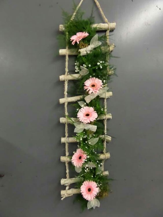 3. Una creazione da parete, con corda, legni, fiori e fiocchi