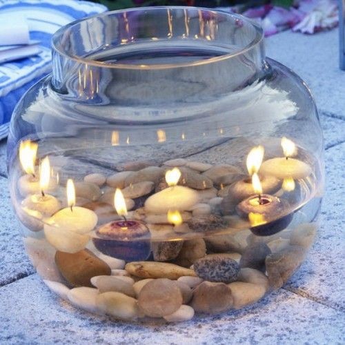 3. Sassolini e conchiglie immersi in acqua sono un fondale magico per delle candeline galleggianti