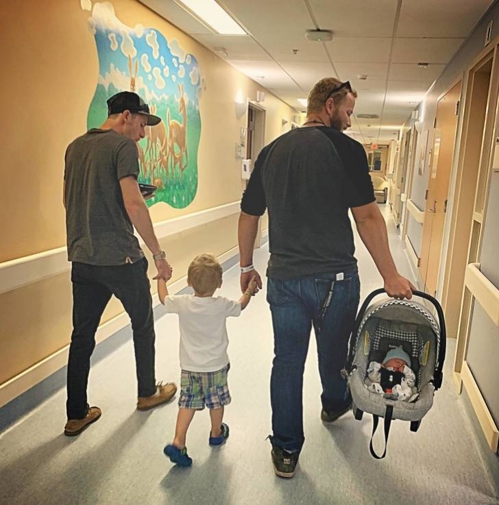 Una mamma commossa fotografa il suo compagno attuale e il suo ex marito mentre escono dall'ospedale con i figli