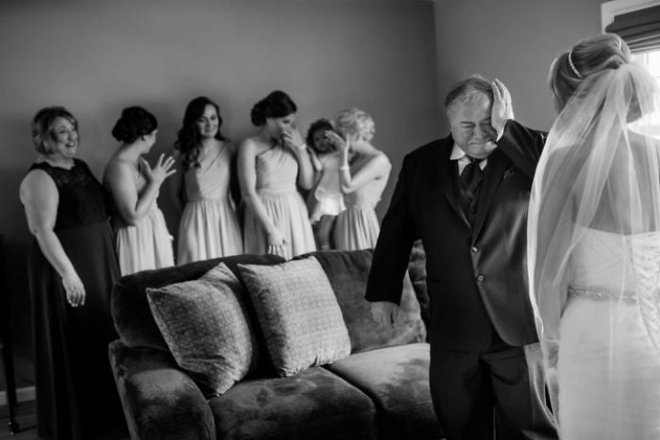 Un père ému devant sa fille en robe de mariée.