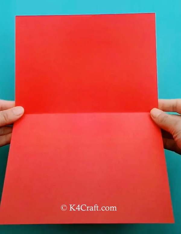1. Ritagliate un rettangolo di carta colorata e piegatelo a metà come in foto