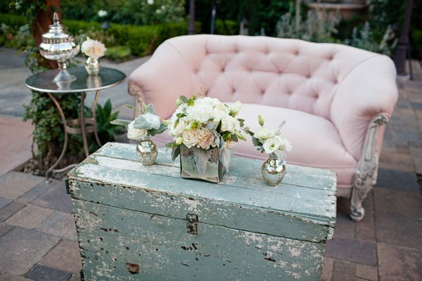 4. Un sofà di altri tempi rosa cipria abbinato a un baule di legno grigio azzurro dall'aspetto sciupato 