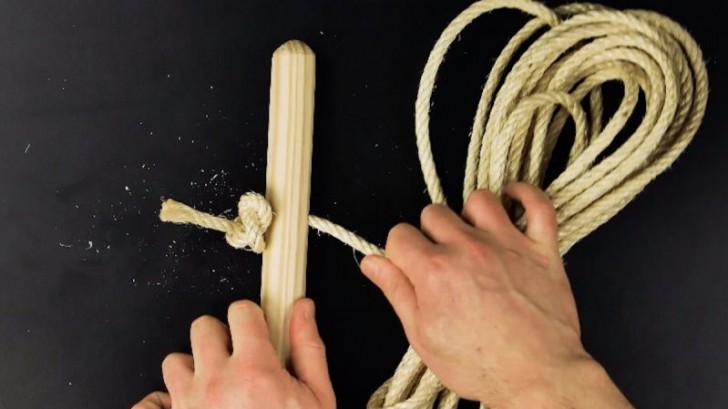 2. Inserite la corda in uno dei bastoni e stringete un nodo in modo che non scorra via
