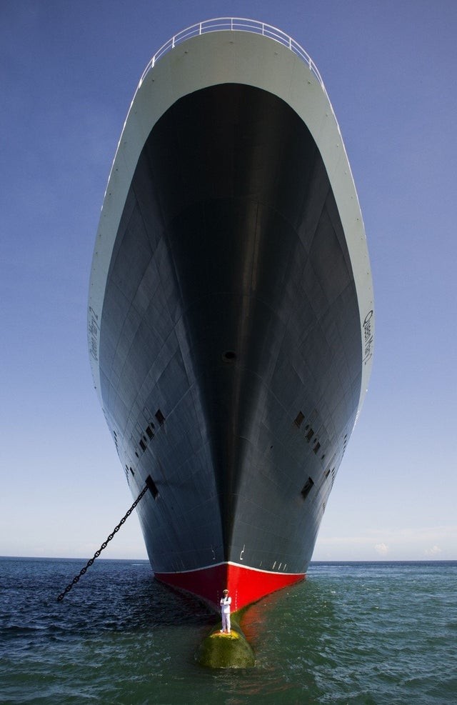 De iconische transatlantische Queen Mary 2 met haar kapitein op de bulb, waardoor je de ware afmetingen begrijpt.