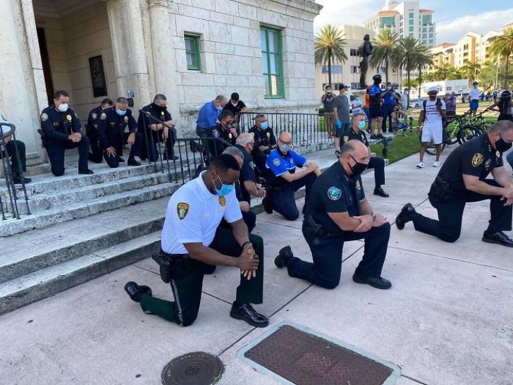Un'immagine potente: le alte cariche della polizia di Miami in Florida si inginocchia pacificamente di fronte ai manifestanti