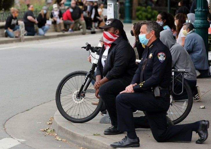 La polizia di Santa Cruz in California si inginocchia di fronte ai protestanti.