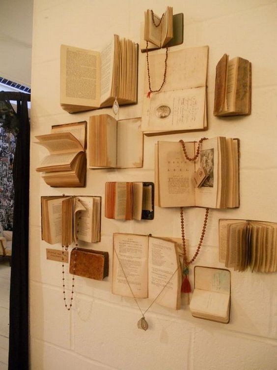 7. Una parete di libri aperti usati sia per decorare che per appendere gioielli