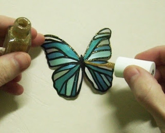 5. Ritagliate per bene la farfalla di plastica e decorate ulteriormente i contorni, magari con uno smalto glitter (oppure con colla e porporina)